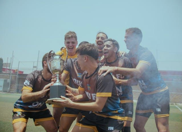 fotbollsspelare lyfter pokal